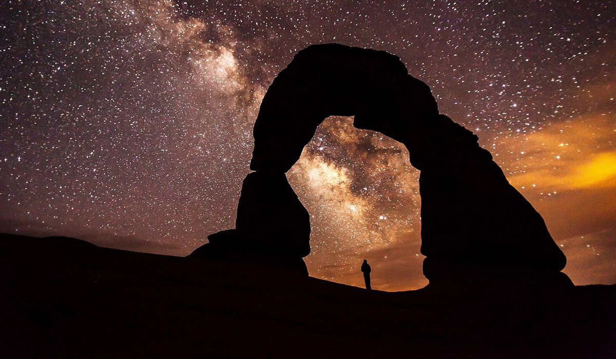 An image of a person staring up at a star-filled night sky.